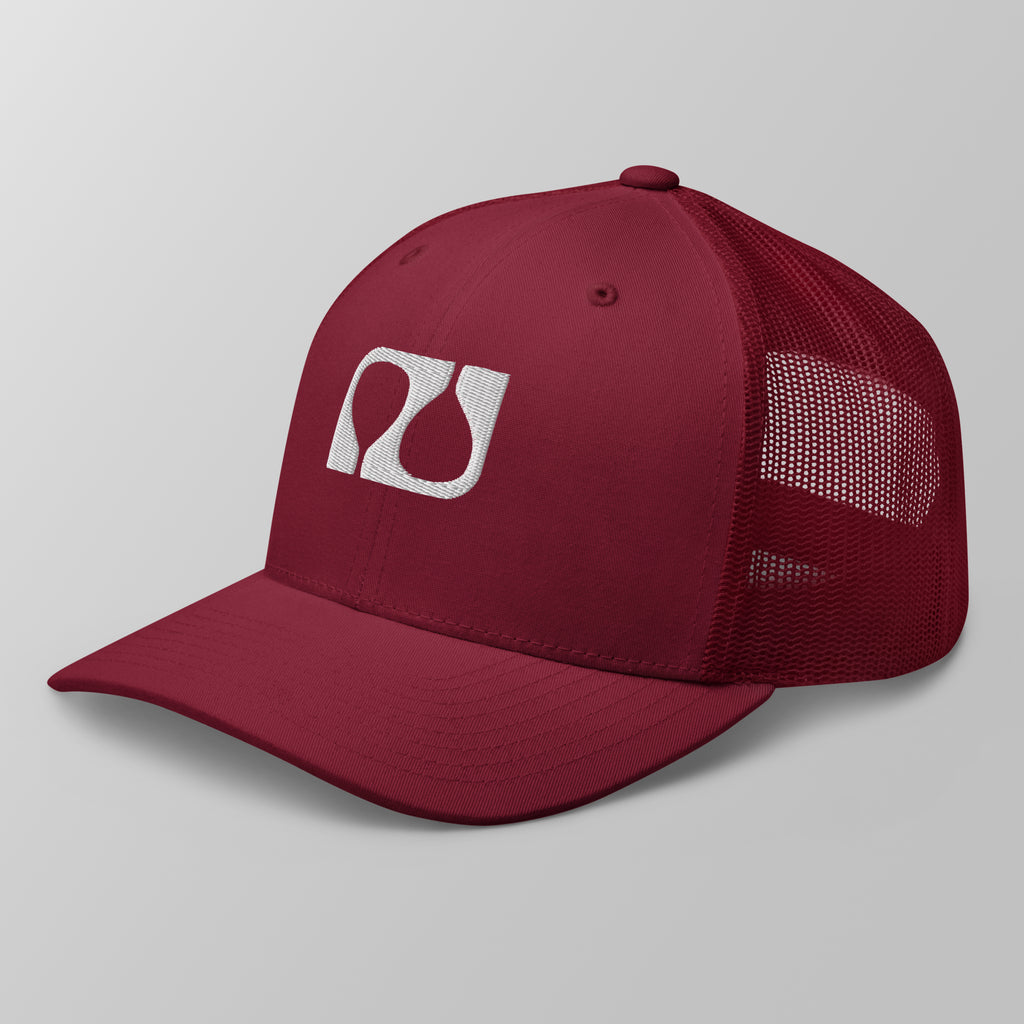 Angled view of a maroon premium padel trucker cap featuring a white embroidered 'Après Padel Society' logo.