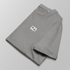 Close-up of a folded heather grey padel t-shirt with a small white logo on the left chest.