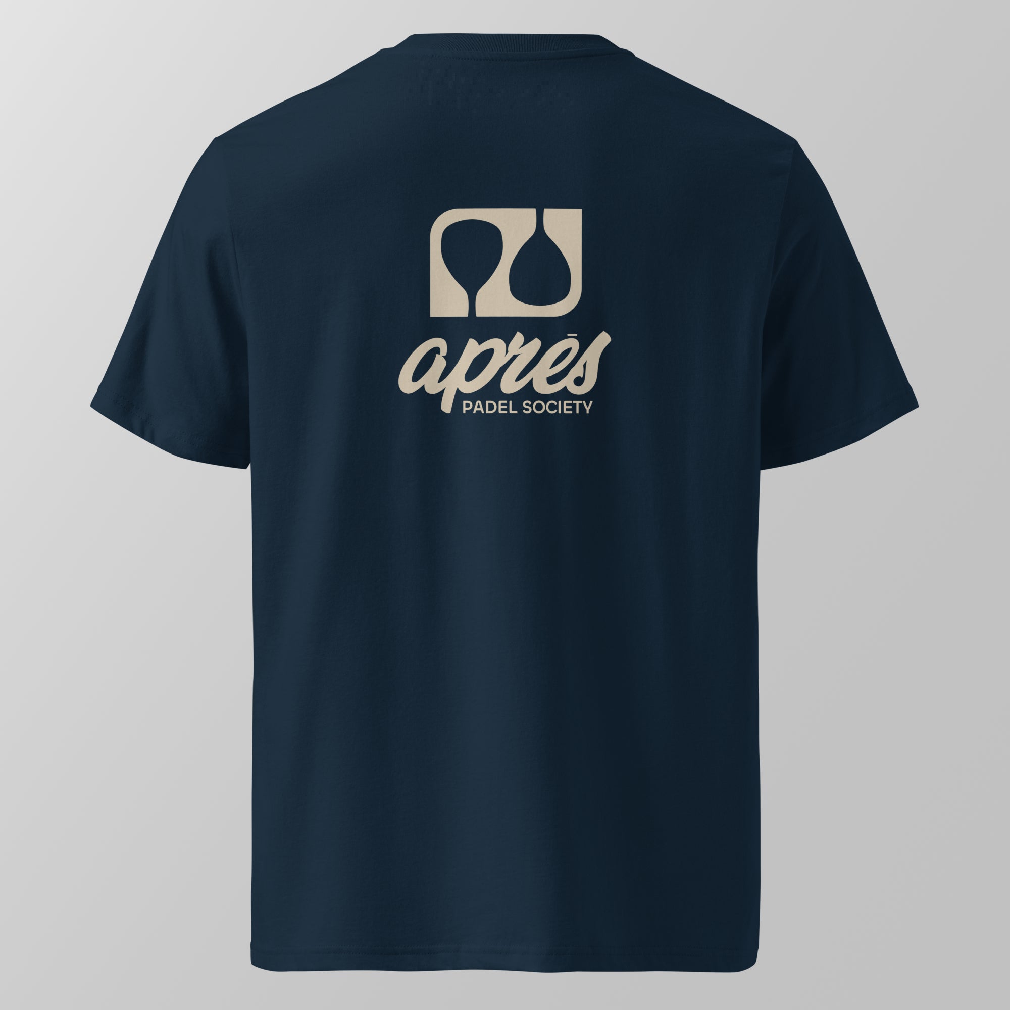 Back view of a navy blue relaxed fit oversized unisex padel t-shirt with the large tan 'Après Padel Society' logo. 