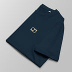 Close-up of a folded navy blue padel t-shirt with a small tan logo on the left chest.