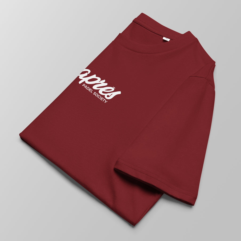 Close-up of a folded maroon padel t-shirt with white 'Après Padel Society' logo centred.
