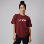 Female model wearing an oversized unisex maroon padel t-shirt in relaxed fit with a white horizontal chest logo.