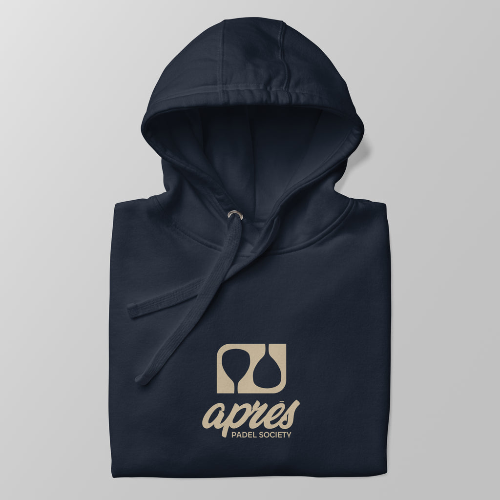 Close-up of a folded navy blue premium padel hoodie with the tan 'Après Padel Society' logo centred.
