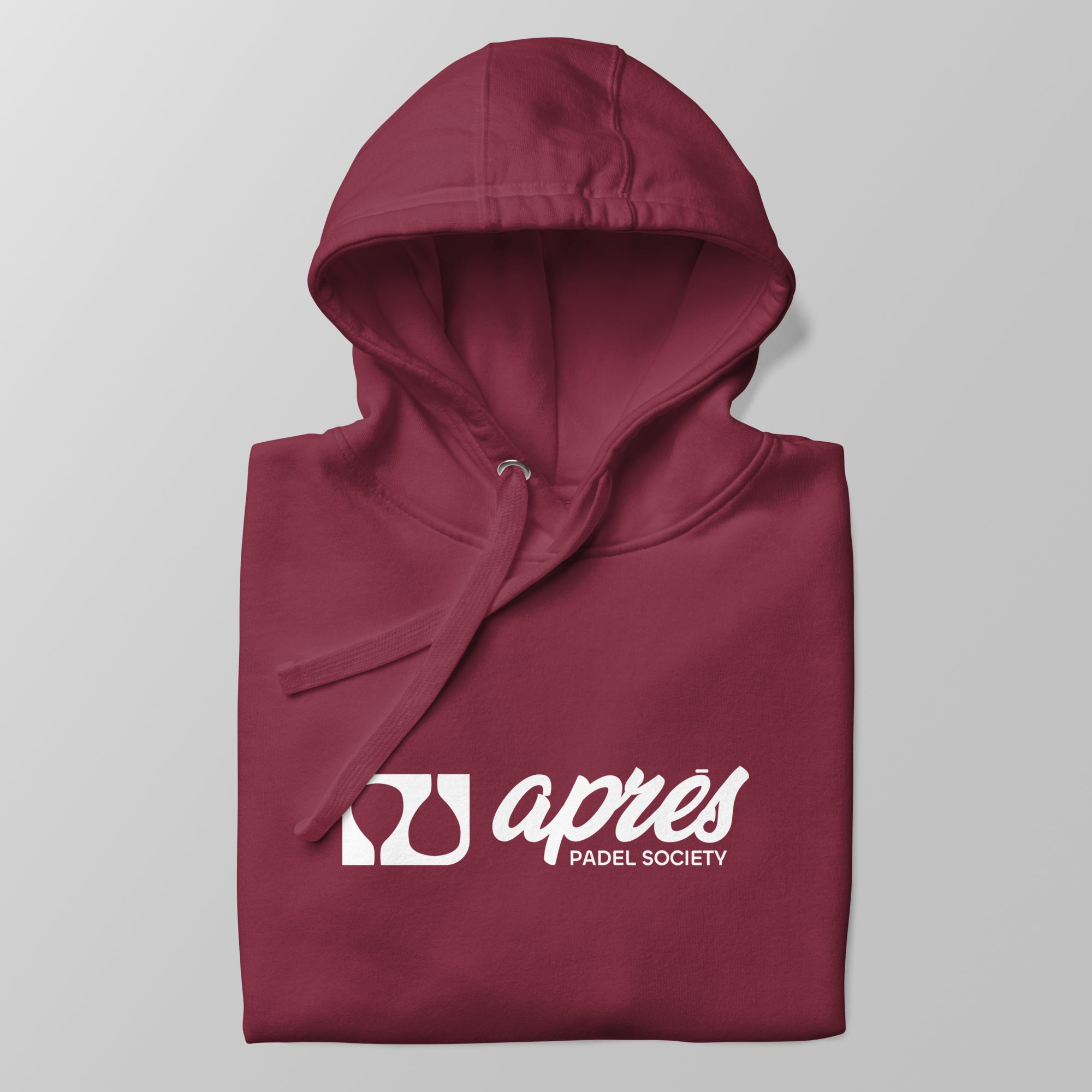 Close-up of a folded maroon premium padel hoodie with the white 'Après Padel Society' logo centred.