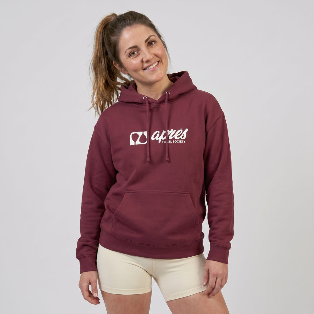 Woman modelling a maroon premium padel hoodie with a white 'Après Padel Society' logo.