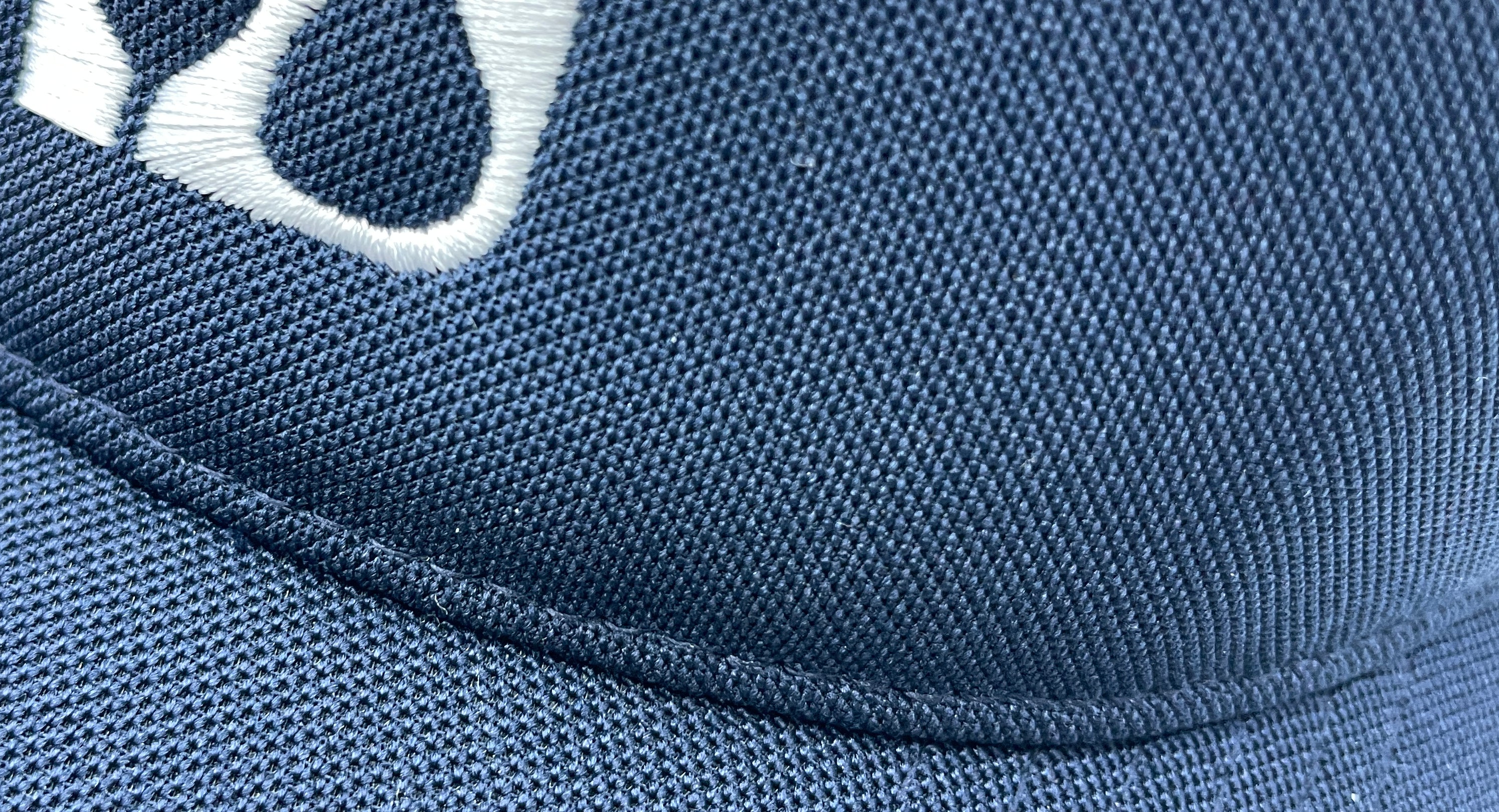 Close-up of a blue cap with white logo 